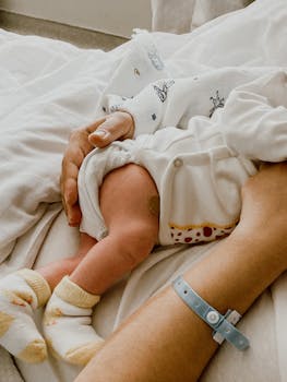 Tender moment captured between mother and newborn baby in a hospital setting.